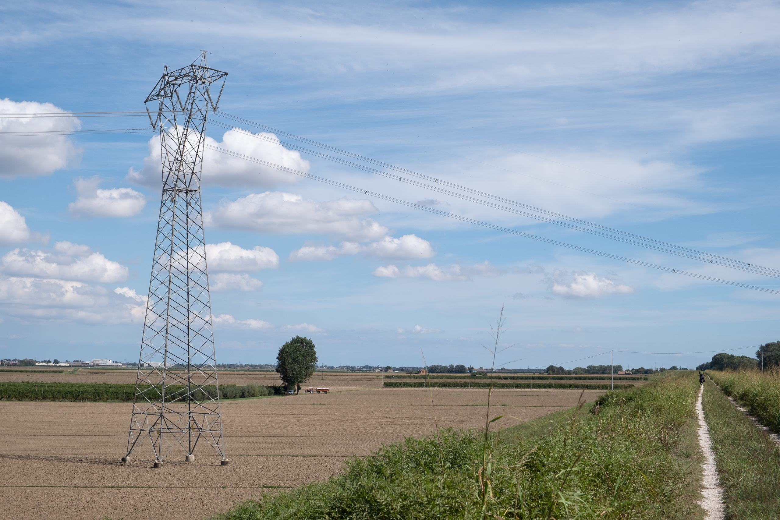 Strommast in der weiten Ebene – Radweg auf dem Damm